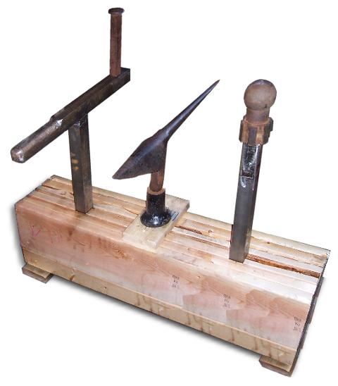Three armourers stakes in heavy wood stake bench